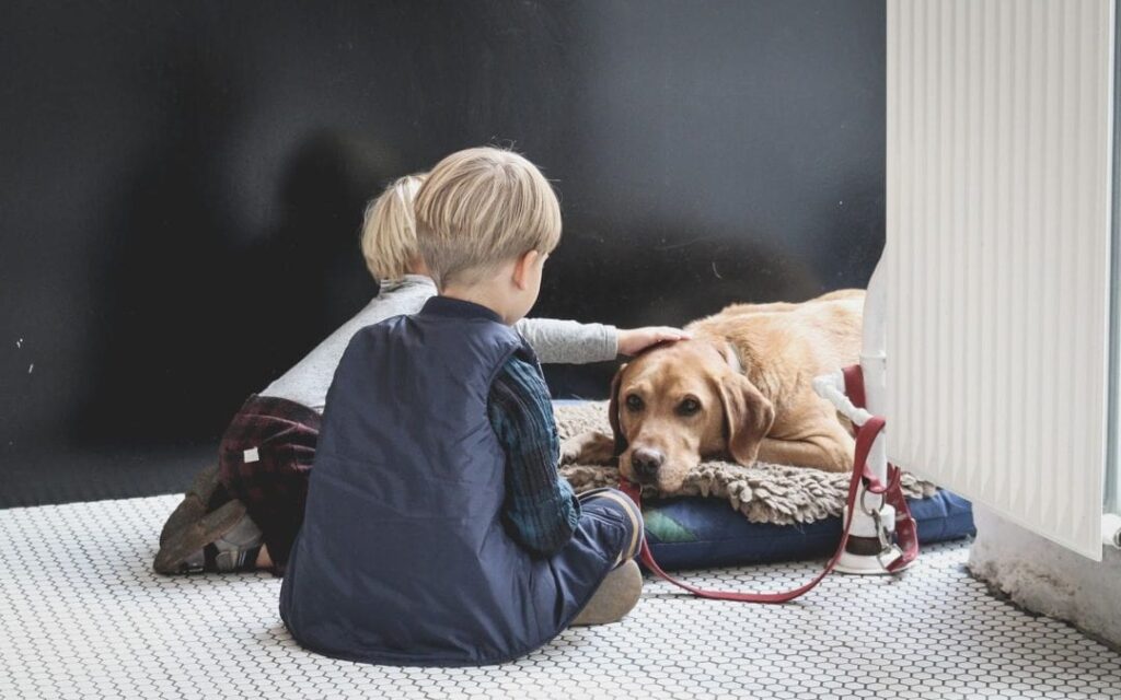 two children and their old dog saying goodbye